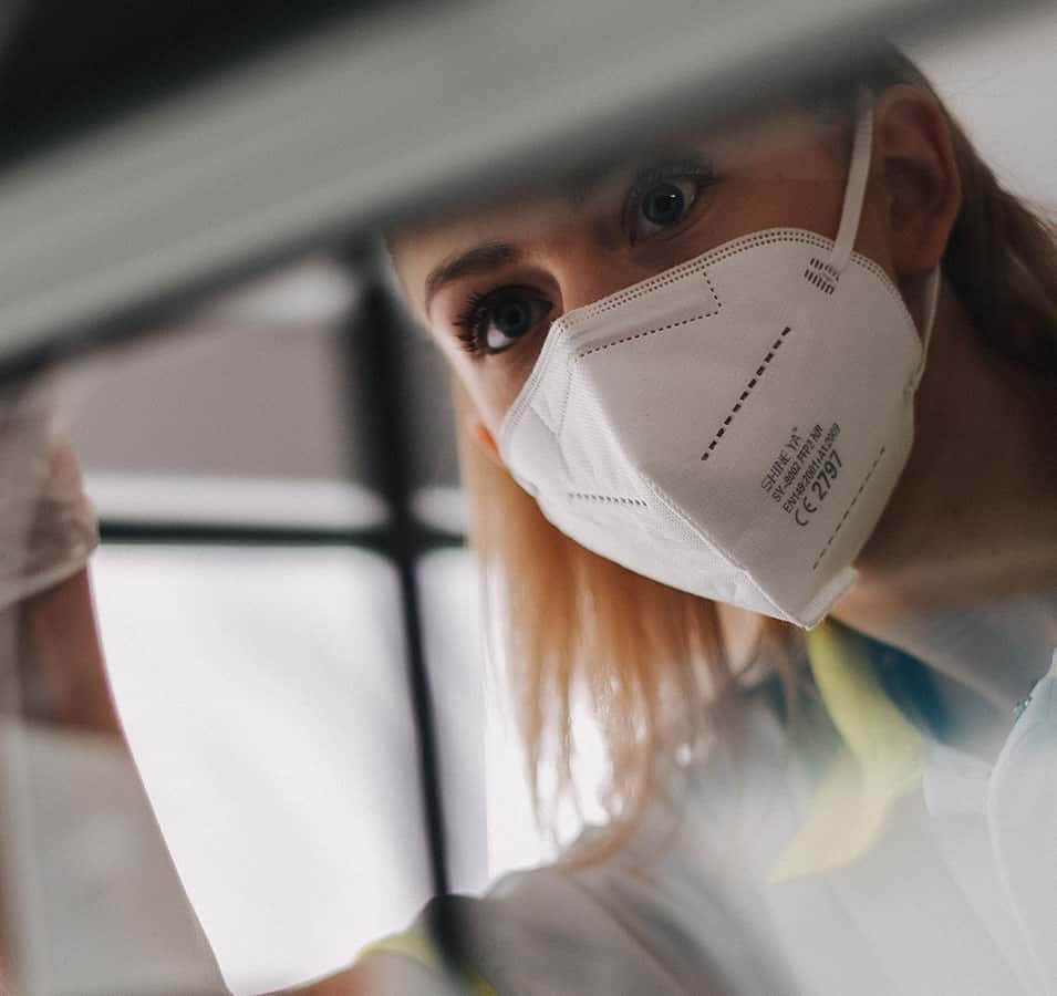 Junge Sanitäterin kontrolliert den Inhalt eines Behälters